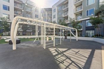 a playground at an apartment complex with a swing set